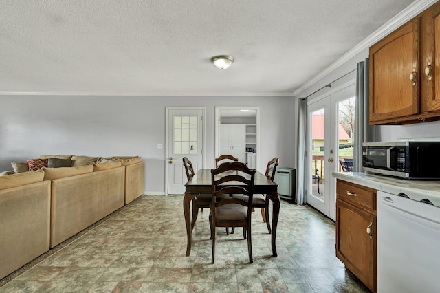 dining room with a textured ceiling, baseboards, crown molding, and french doors