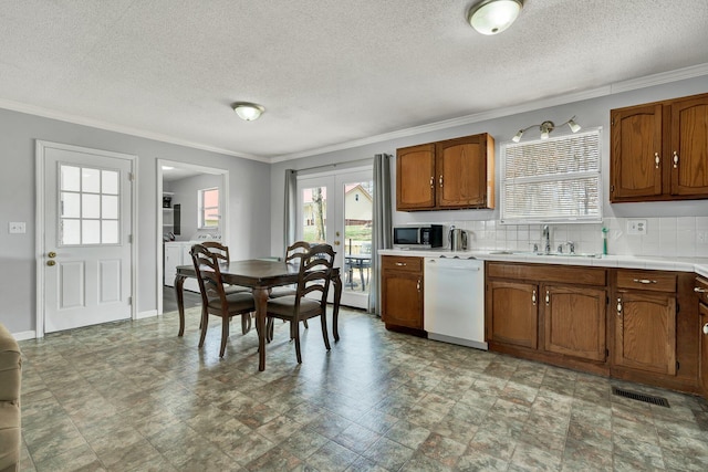 kitchen featuring visible vents, stainless steel microwave, decorative backsplash, a sink, and dishwasher