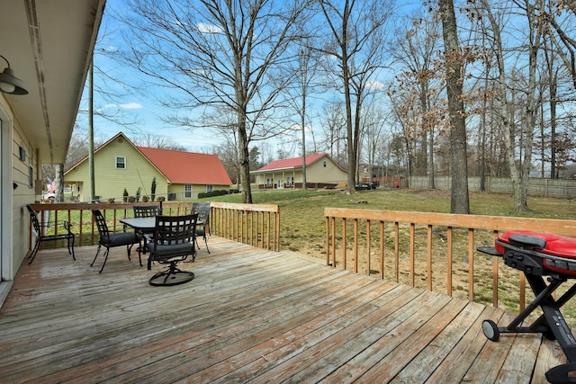 wooden deck with outdoor dining space, a yard, and fence