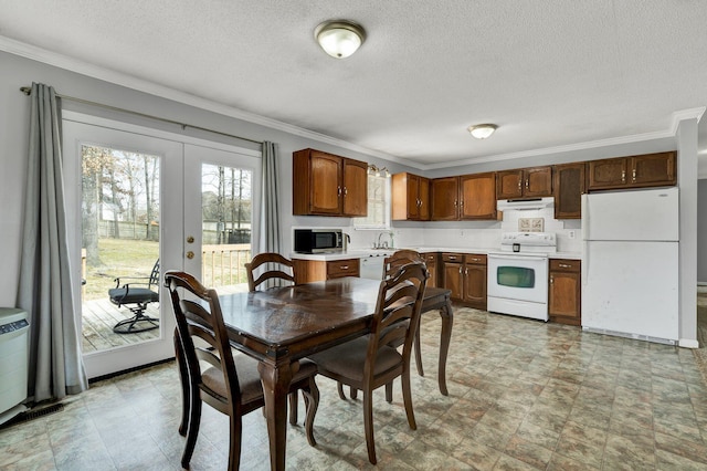 dining area with a textured ceiling, french doors, and crown molding