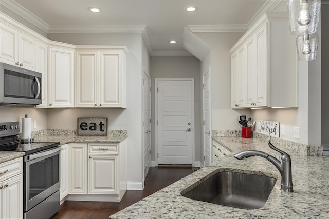 kitchen with light stone countertops, appliances with stainless steel finishes, decorative light fixtures, and sink