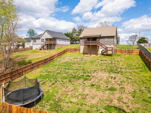 view of yard featuring a deck and a trampoline