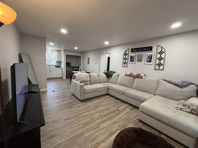 living area featuring light wood-type flooring and recessed lighting