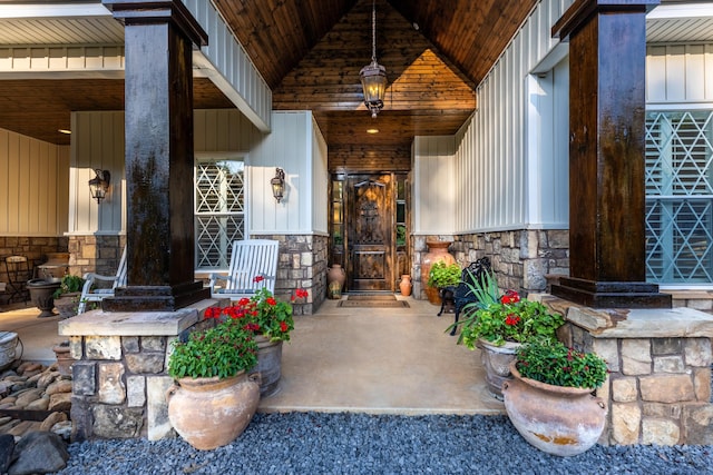 property entrance with board and batten siding and stone siding