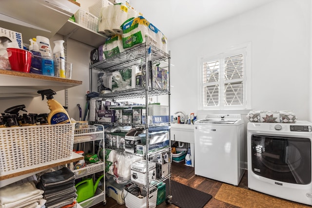 clothes washing area featuring laundry area, washer and clothes dryer, and dark wood-type flooring