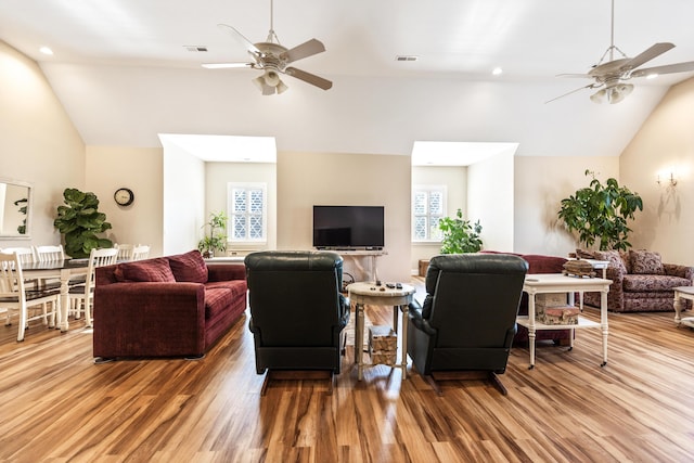 living room featuring vaulted ceiling, ceiling fan, and wood finished floors