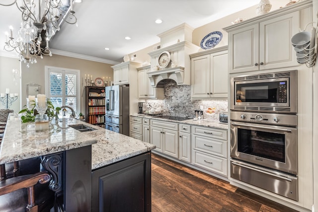 kitchen featuring a warming drawer, stainless steel appliances, a sink, and a center island with sink