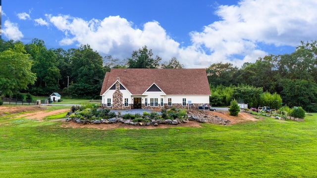 view of front of house with stone siding and a front lawn