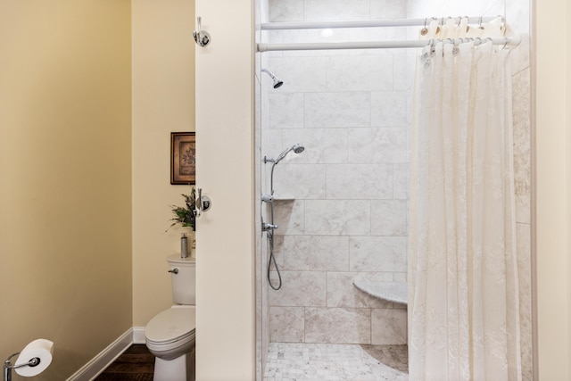 full bath with a shower stall, toilet, and baseboards