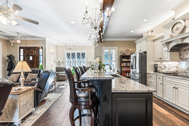 kitchen with a sink, open floor plan, a large island with sink, and high end fridge