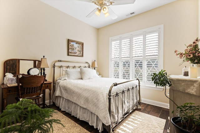 bedroom with visible vents, dark wood finished floors, baseboards, and ceiling fan