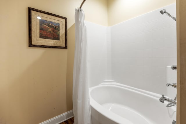 bathroom with baseboards and shower / bath combo with shower curtain