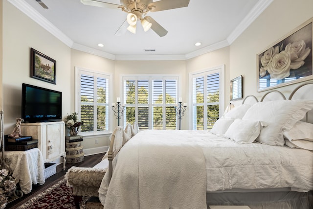 bedroom featuring ornamental molding, visible vents, baseboards, and wood finished floors