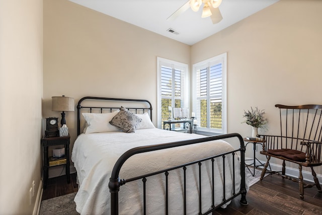 bedroom with dark wood-type flooring, a ceiling fan, visible vents, and baseboards