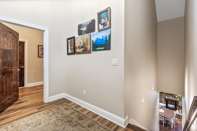 hallway featuring wood finished floors and baseboards