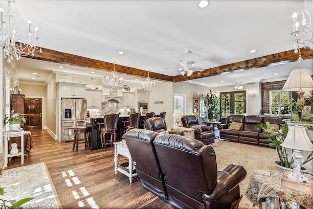 living room featuring recessed lighting, beamed ceiling, crown molding, light wood-style floors, and ceiling fan with notable chandelier