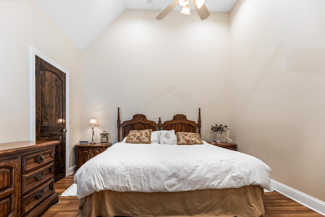 bedroom with vaulted ceiling, baseboards, and dark wood finished floors