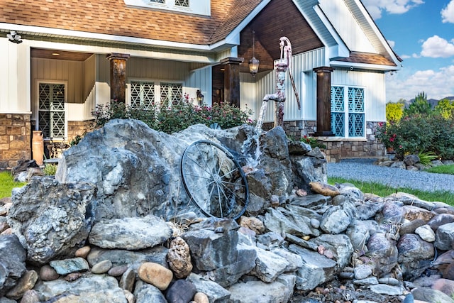 view of home's exterior with a shingled roof and stone siding