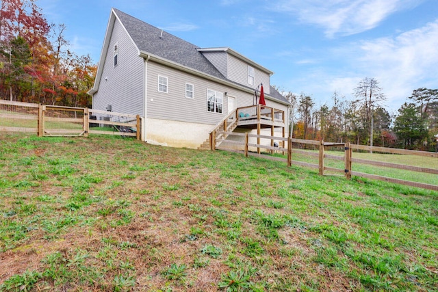 rear view of house featuring a yard and a deck