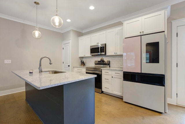 kitchen featuring appliances with stainless steel finishes, white cabinetry, and an island with sink