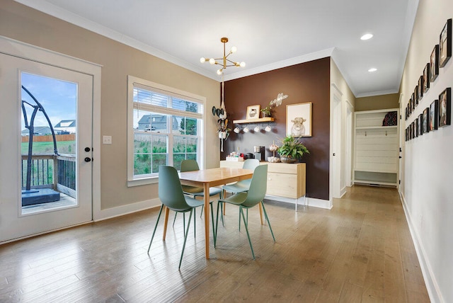 dining area featuring hardwood / wood-style floors, crown molding, and a chandelier