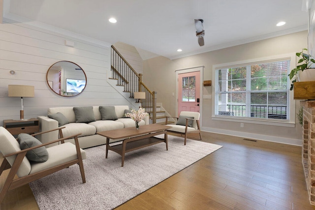 living room with wood walls, dark hardwood / wood-style flooring, and ornamental molding