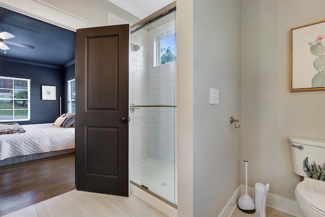 bathroom featuring hardwood / wood-style floors, ceiling fan, toilet, ornamental molding, and a shower with shower door