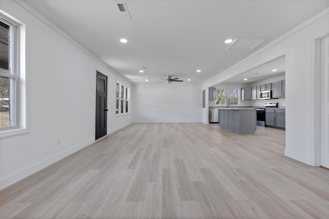 unfurnished living room featuring ceiling fan and light hardwood / wood-style floors