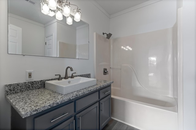 bathroom with vanity, ornamental molding, hardwood / wood-style floors, and shower / tub combination