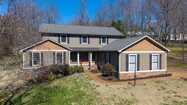 traditional-style house with a front lawn, board and batten siding, and a shingled roof