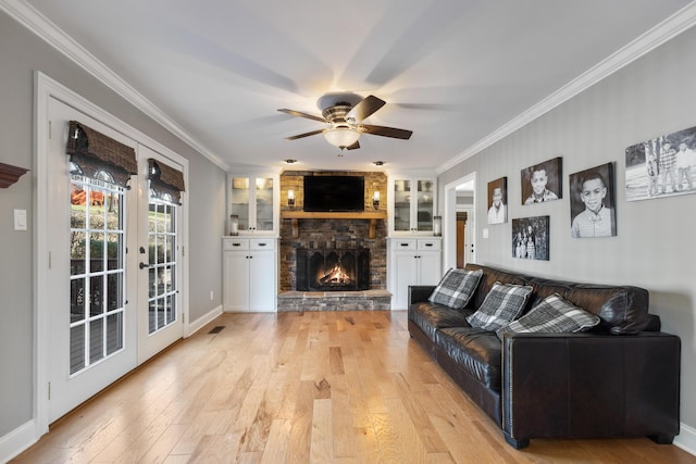 living area featuring french doors, light wood-style flooring, a ceiling fan, and crown molding