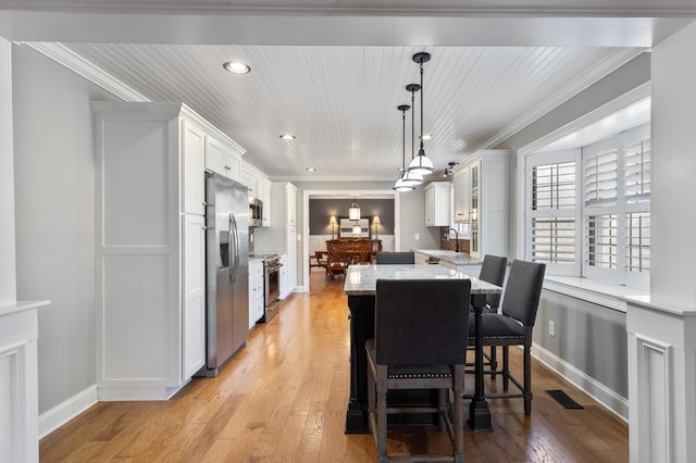 dining area with light wood finished floors, visible vents, and ornamental molding