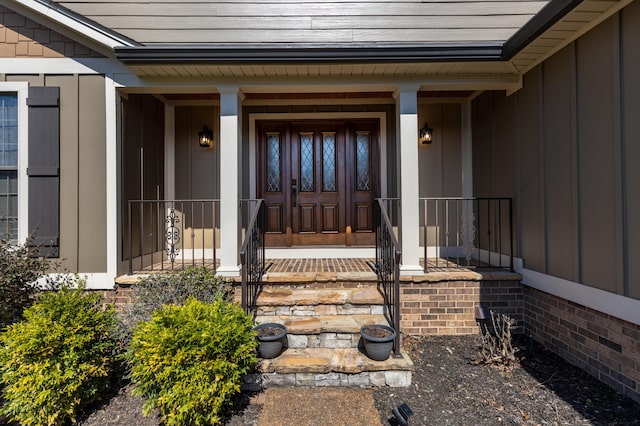 property entrance featuring covered porch and board and batten siding