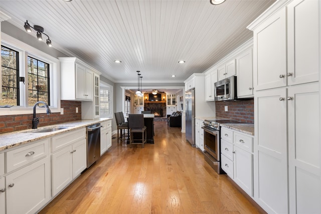 kitchen featuring white cabinets, tasteful backsplash, appliances with stainless steel finishes, and a sink