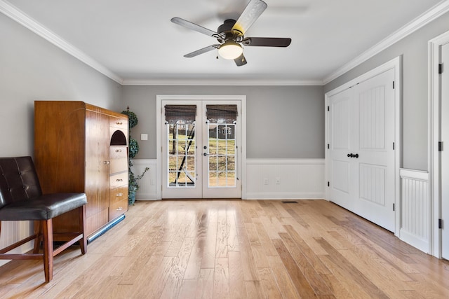 interior space featuring french doors, wood finished floors, a wainscoted wall, and a ceiling fan