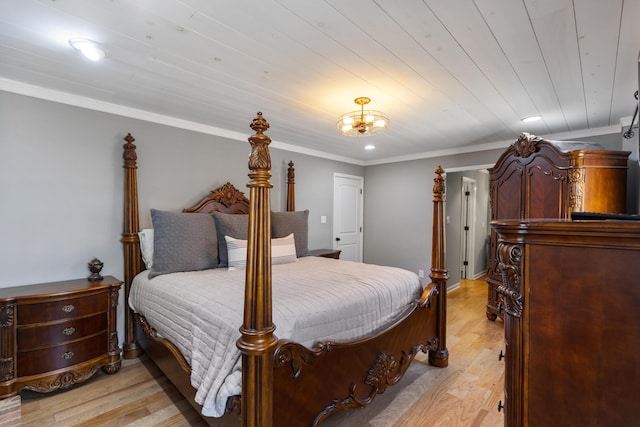 bedroom featuring an inviting chandelier, crown molding, and light wood-style floors