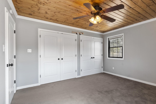 unfurnished bedroom featuring wooden ceiling, baseboards, multiple closets, and ornamental molding