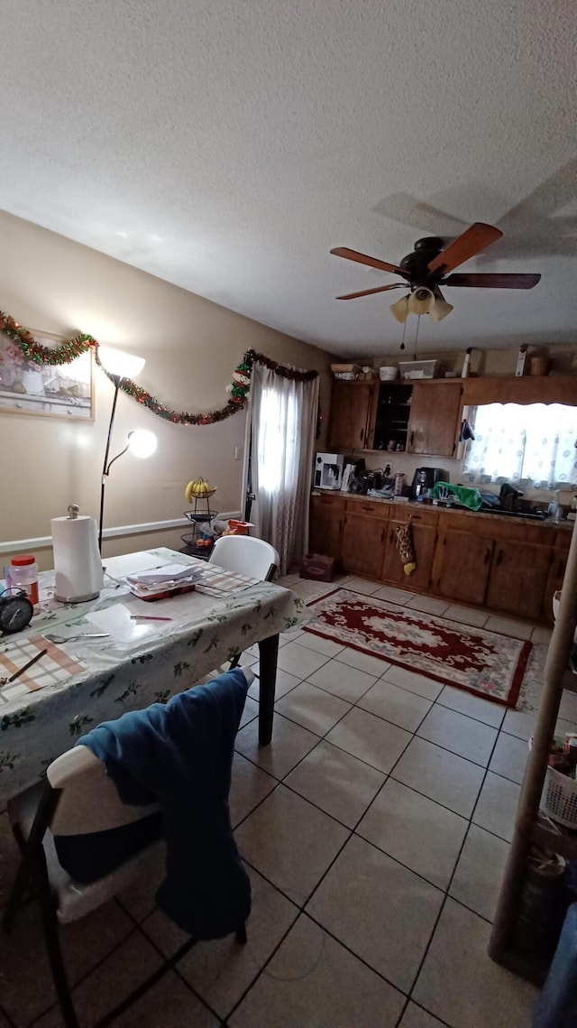 tiled dining room featuring ceiling fan and a textured ceiling