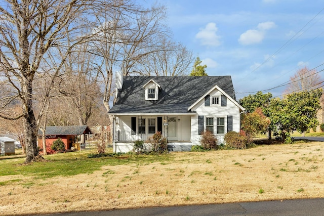 cape cod house featuring a porch, an outdoor structure, and a front lawn