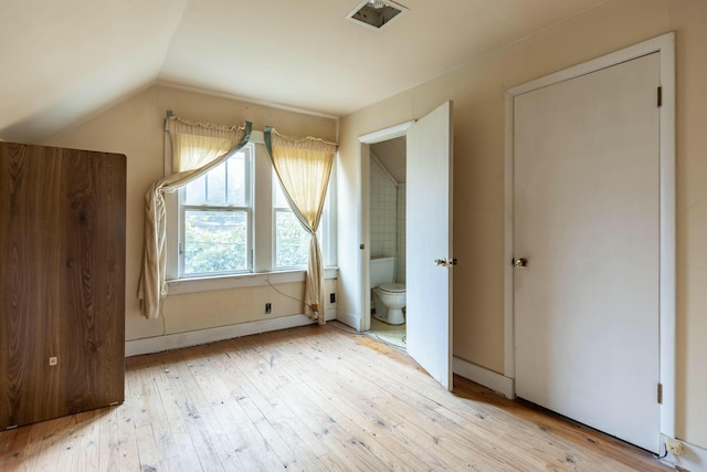 additional living space featuring lofted ceiling, visible vents, and light wood-type flooring