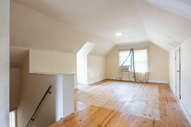 bonus room with baseboards, lofted ceiling, and light wood-style floors