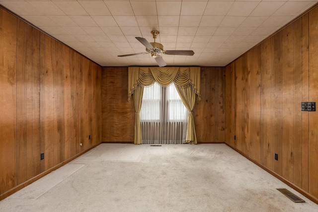 unfurnished room with visible vents and wooden walls