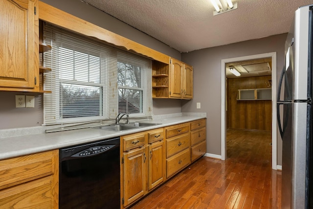 kitchen with a sink, dark wood finished floors, black dishwasher, freestanding refrigerator, and open shelves