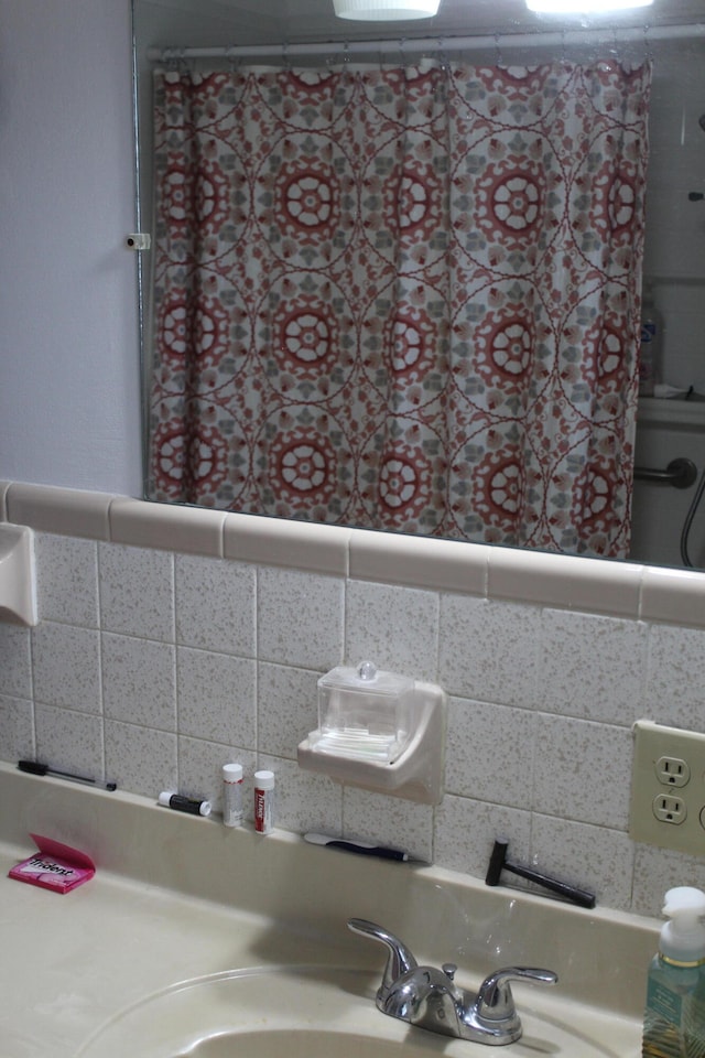 bathroom featuring tasteful backsplash and sink