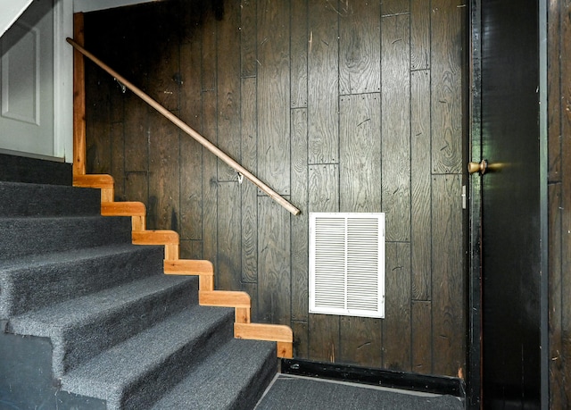 stairs featuring wooden walls