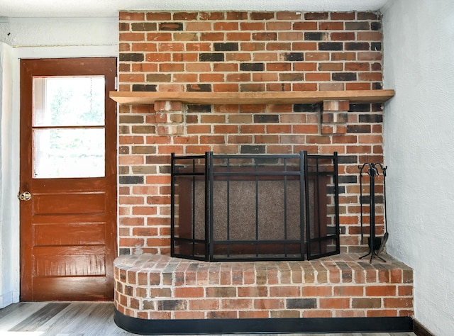 details with hardwood / wood-style floors and a brick fireplace