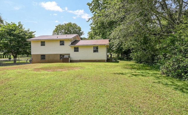 rear view of house with a lawn and cooling unit