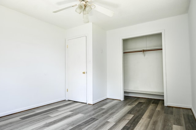 unfurnished bedroom with hardwood / wood-style floors, ceiling fan, and a closet