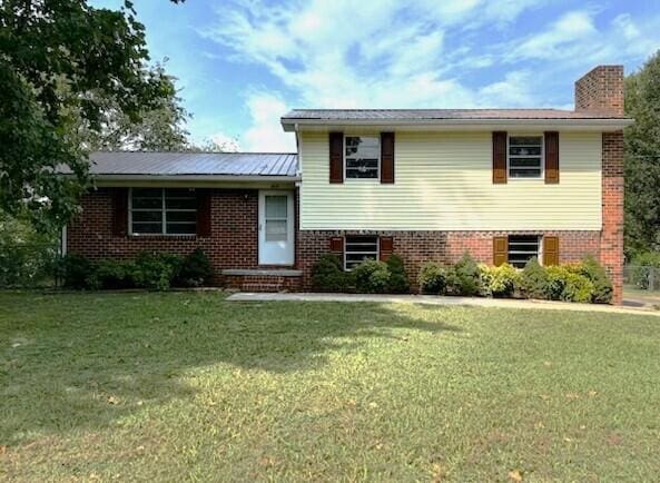 split level home featuring a front lawn