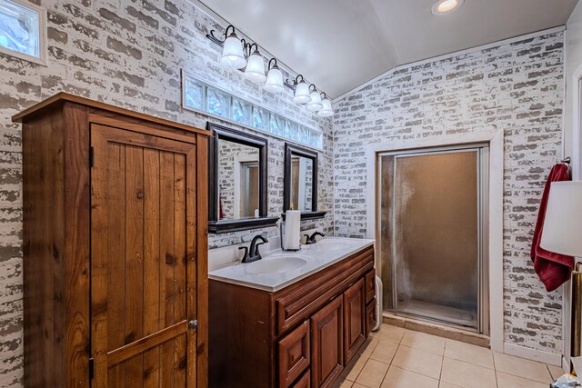 bathroom with tile patterned flooring, vanity, vaulted ceiling, and a shower with door